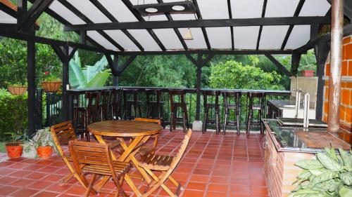 a wooden table and chairs on a patio at Finca PANACA Jagüey 12 VIP Group - Villas for Rent in in Quimbaya