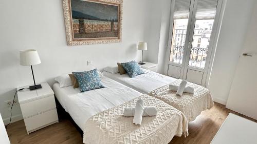 a bedroom with two beds and a picture on the wall at Aldamar Old Town - Romantic Historic Centre in San Sebastián