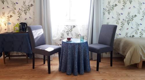 due sedie e un tavolo con una tazza sopra di Mostarlic Vegan and Gluten free B&B a Bouconville