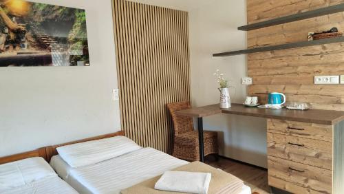 a room with a bed and a desk and a table at Apartmány Mlynky - Slovenský raj in Mlynky 