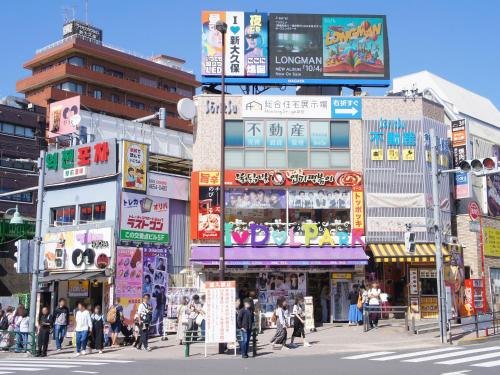 東京にあるアパホテル〈東新宿 歌舞伎町〉の交差点の賑やかな街道