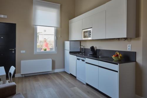uma cozinha com armários brancos e uma bancada em Apartamentos Cuerda Larga em Madri