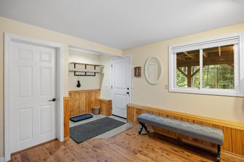 um quarto com uma porta, uma janela e um banco em Leisure Chalet close to Lake, Gunstock, Bank of New Hampshire Pavilion. em Gilford