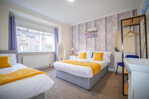 um quarto de hotel com duas camas e um lavatório em Lochlash 3 Bedroom House Inverness em Inverness