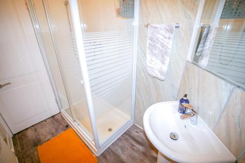 uma casa de banho com um chuveiro e um lavatório. em Lochlash 3 Bedroom House Inverness em Inverness