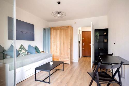 un salon avec un canapé et une table dans l'établissement L'Amarante, T1 avec Terrasse, Beaux Arts, à Montpellier