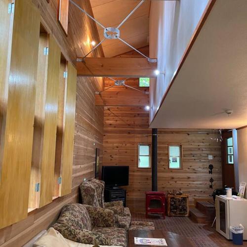 a living room with two chairs and a tv at Kitakaruizawa Morino Bessou NO1 in Kita-karuizawa