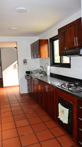 a kitchen with wooden cabinets and a stove top oven at Finca PANACA Jagüey 12 VIP Group - Villas for Rent in in Quimbaya