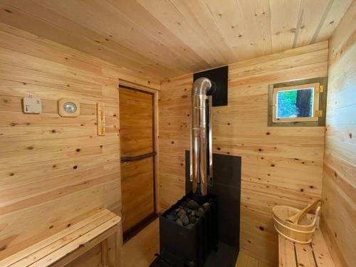 a wooden cabin with a stove in the corner at Kitakaruizawa Morino Bessou NO1 in Kita-karuizawa