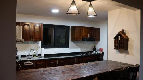a kitchen with wooden cabinets and a counter top at Finca PANACA Jagüey 12 VIP Group - Villas for Rent in in Quimbaya