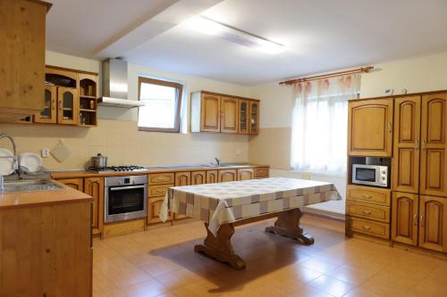 a kitchen with wooden cabinets and a table in it at Pensiunea Aries in Arieşeni