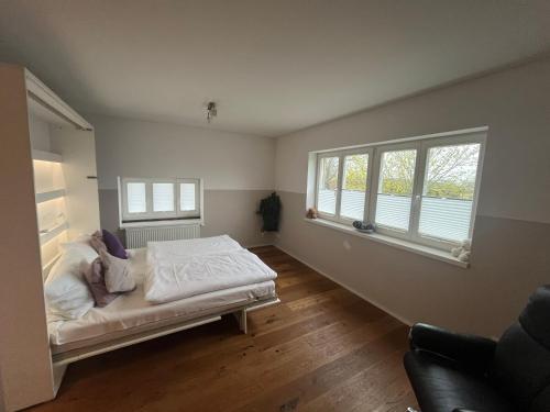 ein Schlafzimmer mit einem Bett und zwei Fenstern in der Unterkunft Luxusferienhaus Isernhagen in Altwarmbüchen
