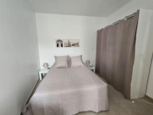 une chambre avec un lit dans une pièce blanche dans l'établissement Maison * 2/4 pers* Jard sur Mer, à Jard-sur-Mer