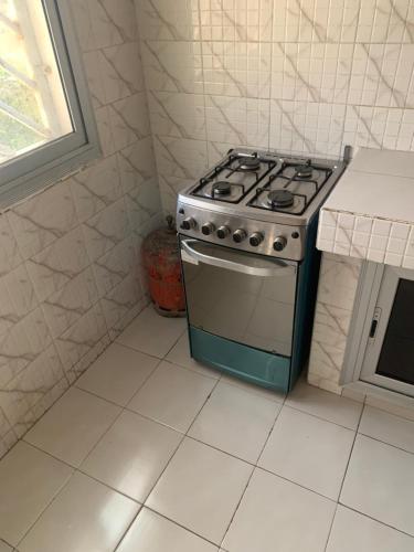 a stove in a kitchen with a white floor at Appartement chambre meublée 1 in Dakar