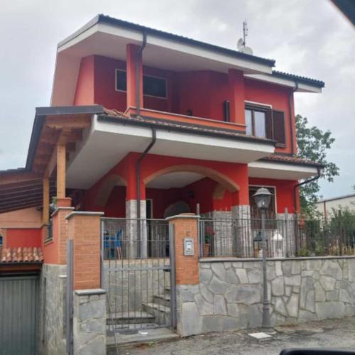 una casa roja con una valla delante en la casa di Camilla, en Volvera