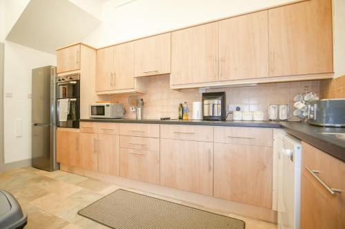 a kitchen with wooden cabinets and stainless steel appliances at Telford Rd 5 Bedroom House Inverness in Inverness