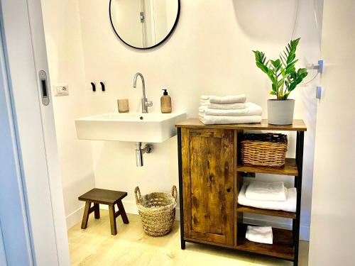 W łazience znajduje się umywalka i lustro. w obiekcie Milano Modern Home w Mediolanie