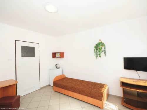a bedroom with a bed and a flat screen tv at U Gosi in Jarosławiec