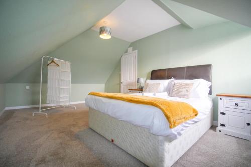 a bedroom with a large white bed with an orange blanket at Telford St 4 Bedroom House Inverness in Inverness