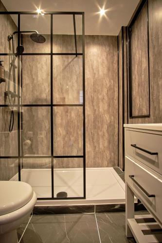 a bathroom with a shower and a toilet and a sink at Muthu Oban Regent Hotel in Oban