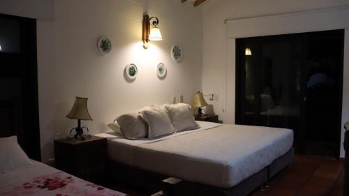 a bedroom with a bed with white sheets and pillows at Finca PANACA Jagüey 12 VIP Group - Villas for Rent in in Quimbaya