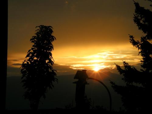 a sunset with the sun setting in the background at Hotel Garni Gästehaus Karin in Sankt Stefan im Lavanttal