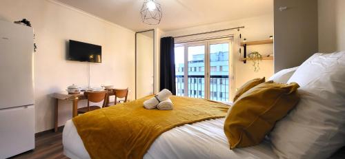 een slaapkamer met een bed met een tafel en een raam bij Le Ciel: Studio 30m2, sans vis-à-vis, RERB à 12min in Bourg-la-Reine