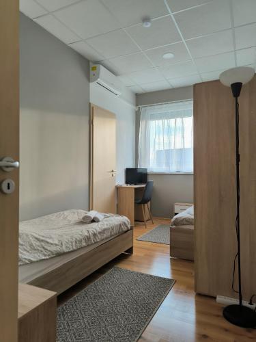 a bedroom with a bed and a desk with a lamp at Szilas Park Motel in Nagytarcsa