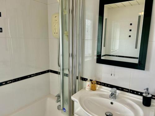 a white bathroom with a sink and a shower at Aitkenhead house by Klass Living in Coatbridge