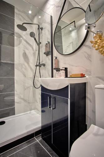 a bathroom with a sink and a shower and a mirror at Muthu Oban Regent Hotel in Oban
