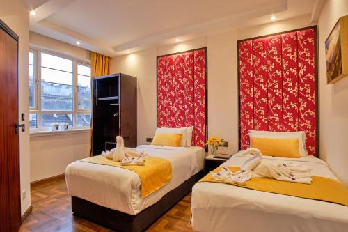 two beds in a room with red curtains at Muthu Oban Regent Hotel in Oban