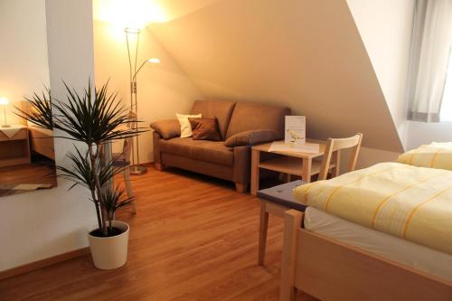 a living room with a couch and a table at Hotel Am Wintergarten in Bocholt
