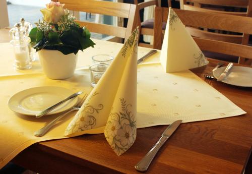 a table with a yellow table cloth with napkins on it at Hotel Am Wintergarten in Bocholt