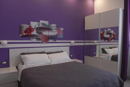 Dormitorio púrpura con cama y espejo en Apartment Nido di Roma Suite, Jacuzzi King Size, Metro C en Roma