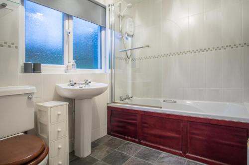 a bathroom with a sink and a tub and a toilet at Mynydd Crwn Bach Clynderwen in Clynderwen