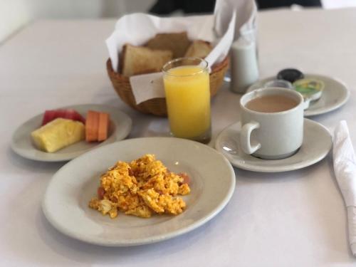 a table with plates of food and a cup of orange juice at San Martin Cartagena in Cartagena de Indias
