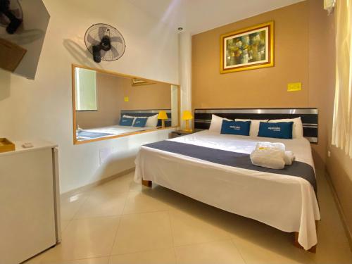 ein Schlafzimmer mit einem großen Bett und einem Spiegel in der Unterkunft Suite Apart Miraflores in Piura
