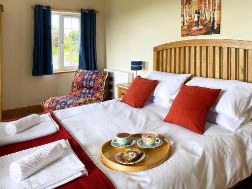 a hotel room with a bed with a tray of food on it at Bryn Y Gog Tregaron in Tregaron