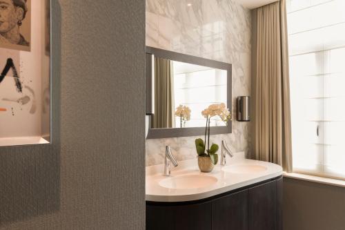 uma casa de banho com um lavatório e um espelho em Hotel Aragon em Bruges