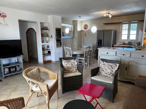 eine Küche und ein Wohnzimmer mit einem Tisch und Stühlen in der Unterkunft Marina 4 adultes 4 enfants piscine commune in Aigues-Mortes