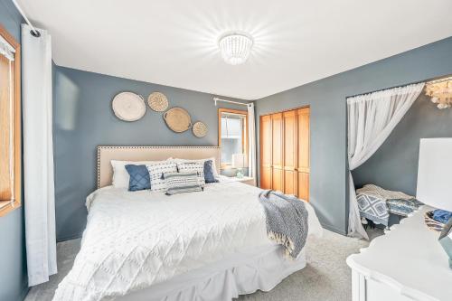 um quarto com uma cama branca e uma parede azul em Salt & Serenity Large home for seven near beach access with private spa! em Lincoln City