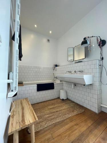 La salle de bains est pourvue d'un lavabo et d'un banc. dans l'établissement Paris JO 2024 - Maison aux airs de vacances, à Colombes