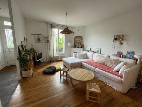 un salon avec un canapé et une table dans l'établissement Paris JO 2024 - Maison aux airs de vacances, à Colombes