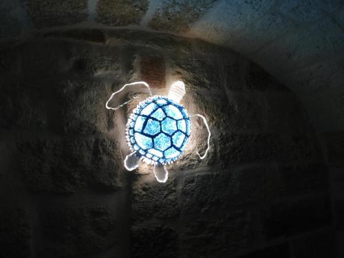 a blue turtle decoration on a brick wall at Aeris Suite & Relax in Polignano a Mare