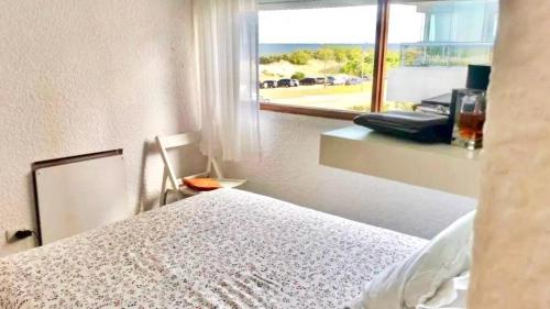 1 dormitorio con cama y vistas al océano en Apartamento frente al mar, en Punta del Este
