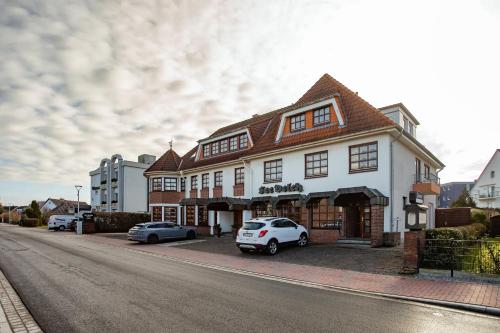 a white car parked in front of a building at Lieblingsplatz Hotel Seedeich in Grömitz