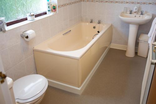 La salle de bains est pourvue d'une baignoire, de toilettes et d'un lavabo. dans l'établissement Soar Cottage Aberystwyth, à Aberystwyth