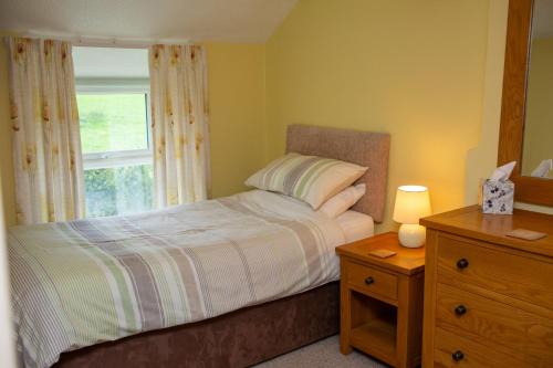a small bedroom with a bed and a window at Soar Cottage Aberystwyth in Aberystwyth