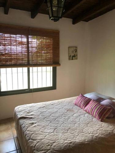 een slaapkamer met een bed waarop een kussen ligt bij Finca, La Joya in Ciudad Lujan de Cuyo