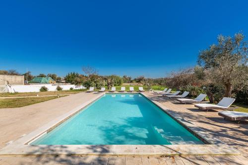 una piscina con tumbonas alrededor en Agriturismo Masseria Carrone, en Carovigno